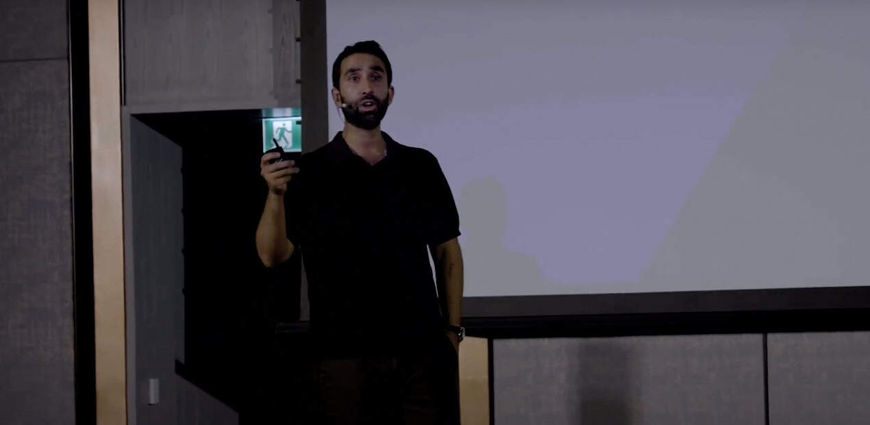 Manick Bhan speaking at an event during a professional engagement.
